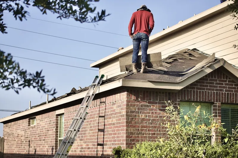 Professional roofer working on a residential roof in Quinebaug